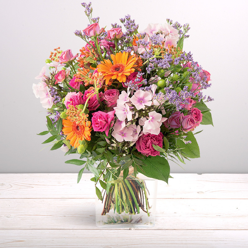 Bouquet rond de roses et fleurs variées aux teintes orange et fuchsia